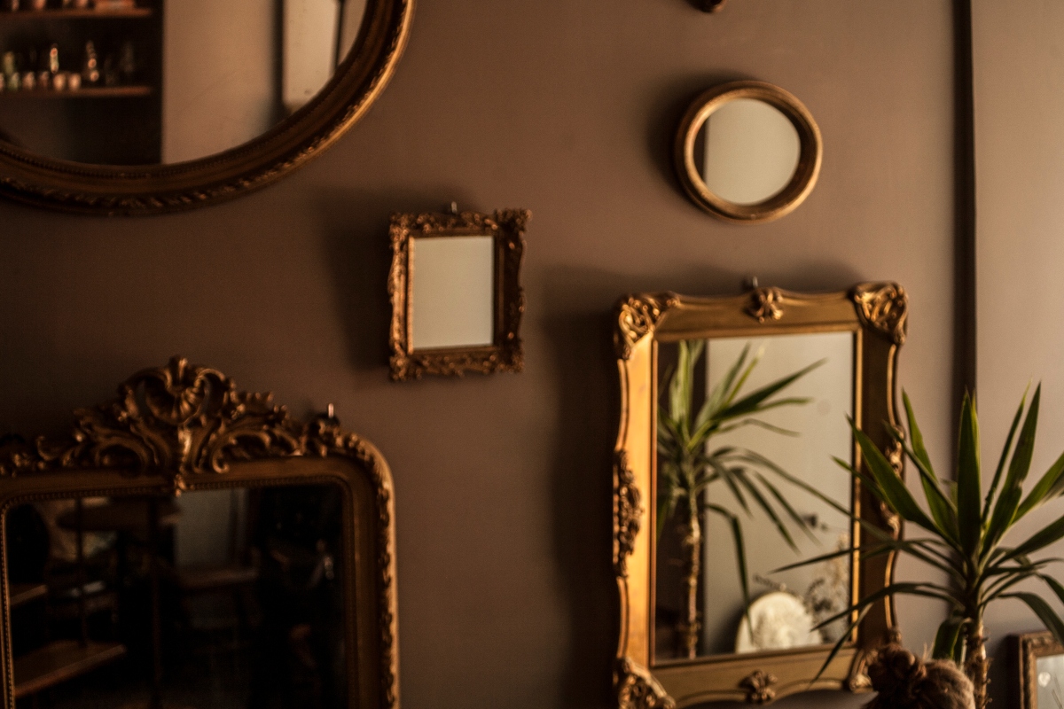 Multiple antique mirrors on a gallery wall